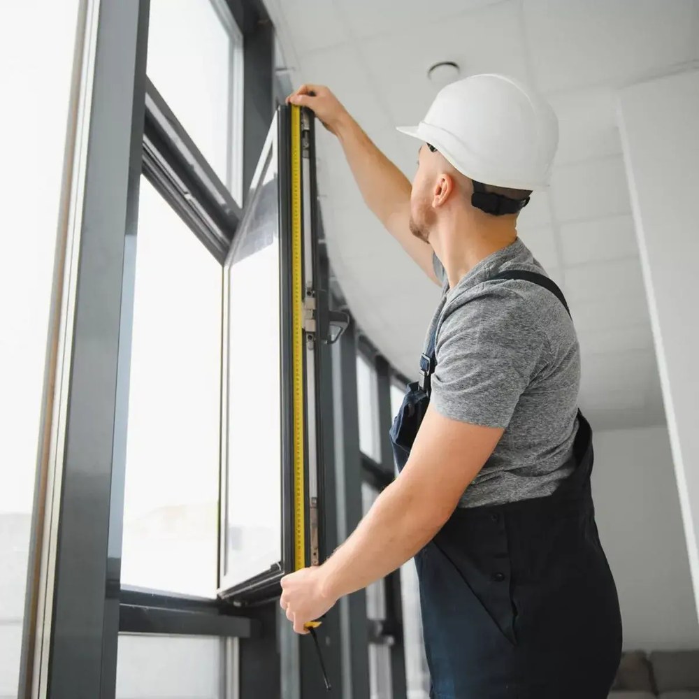 Andrus Window Co. installer measuring and finishing a new window install in North Texas